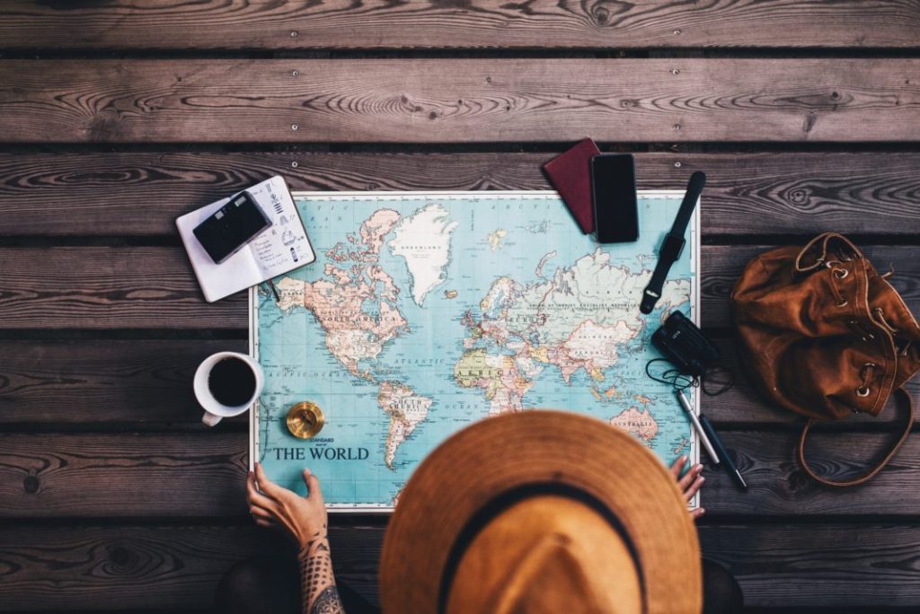 map and coffee cup, phone ,book, bag on a wooden table